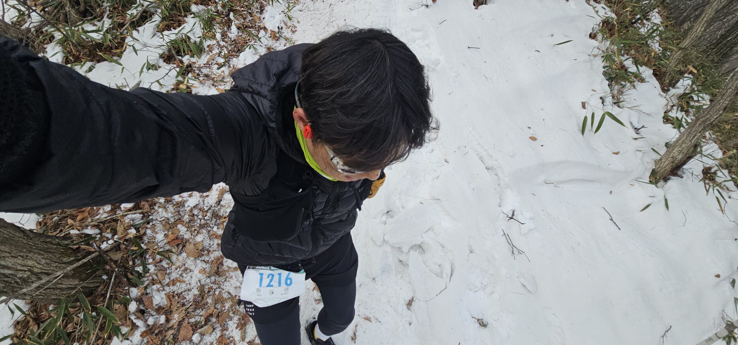 Korea Snow Trail 빙판이 남은 내리막 구간에서 균형을 잡으며 조심스럽게 내려오는 겨울 트레일 러너
