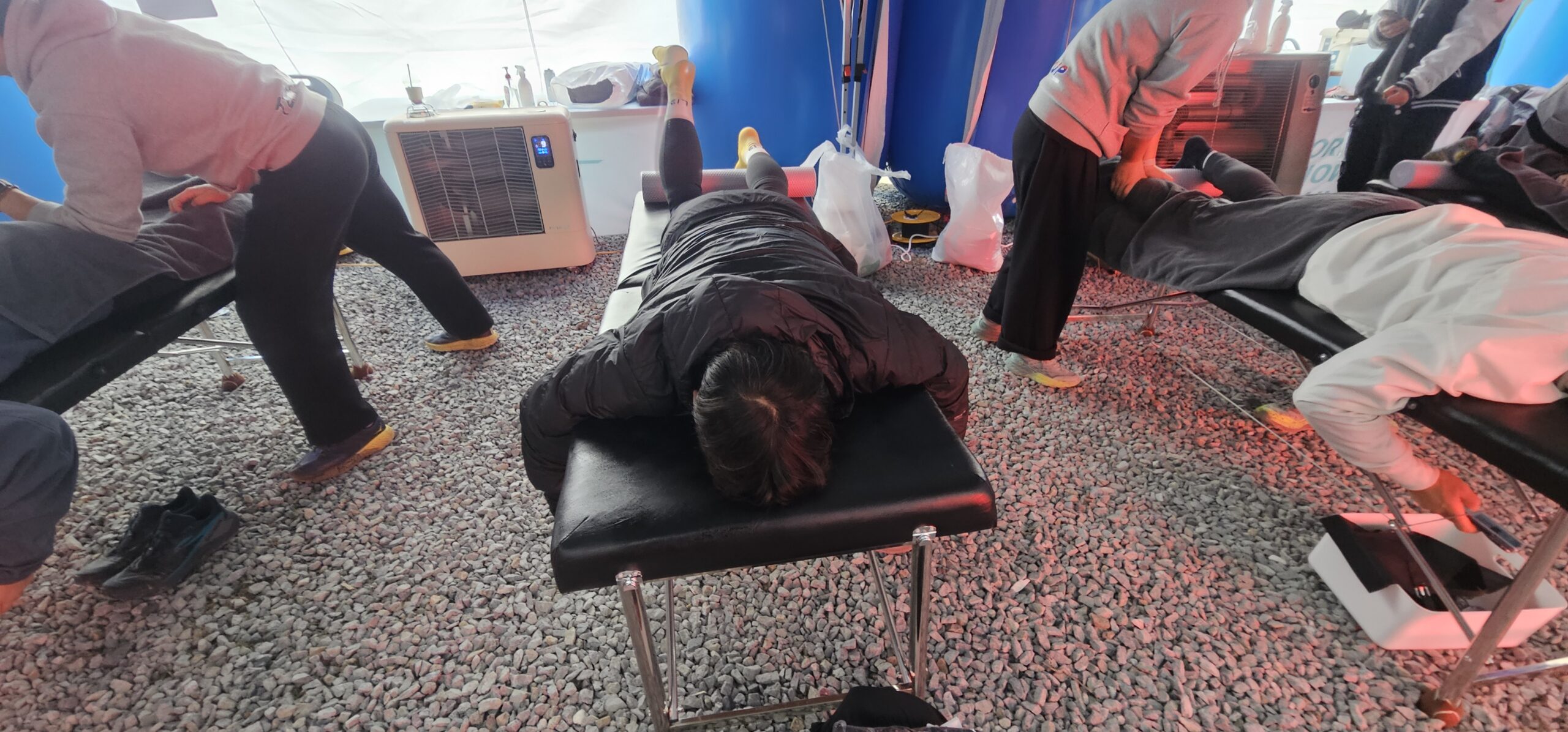 Korea Snow Trail 완주 후 제공된 안마 케어로 지친 다리를 회복하는 트레일 러너
